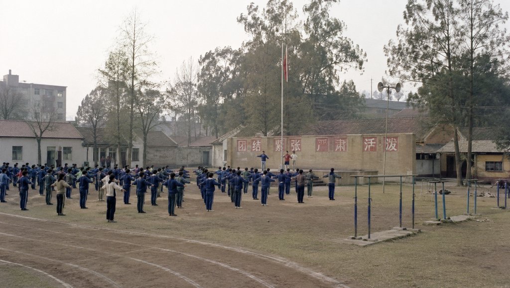 学校操场,土质跑道,学生做操,升旗台与单双杠,怀旧写实风格