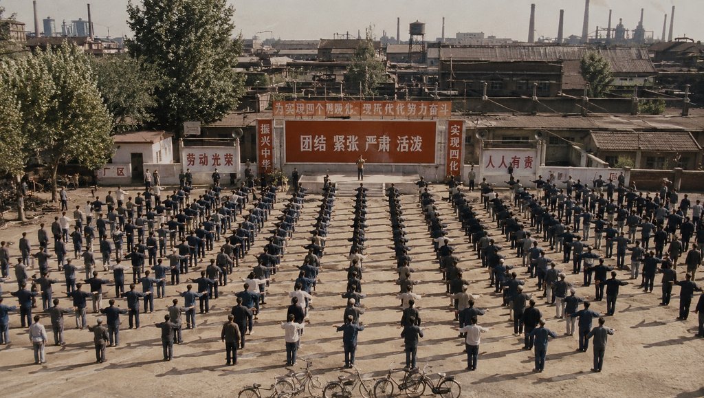 年代工厂工人集体做广播操，整齐列队，背景标语与工业建筑，写实怀旧风格
