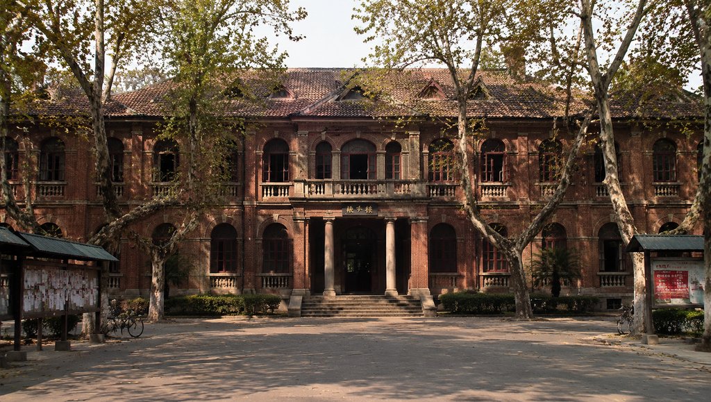 苏式大学红楼，红砖建筑配立柱拱窗，梧桐树环绕，年代感怀旧写实风格