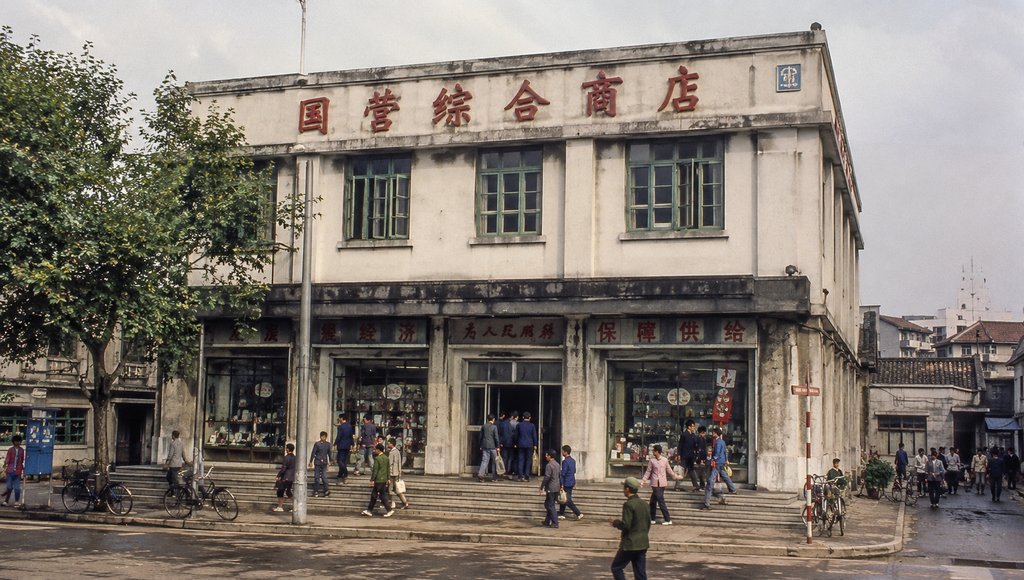 国营商店建筑，红色大字招牌，玻璃橱窗，台阶入口，年代感怀旧写实风格