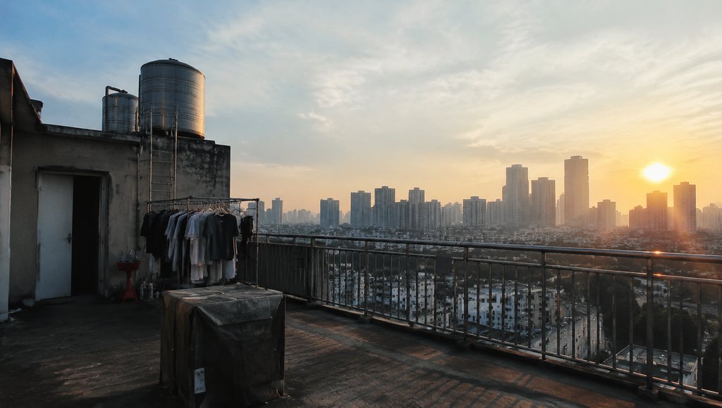 出租屋天台,水箱与晾衣架,城市远景,现代都市写实场景