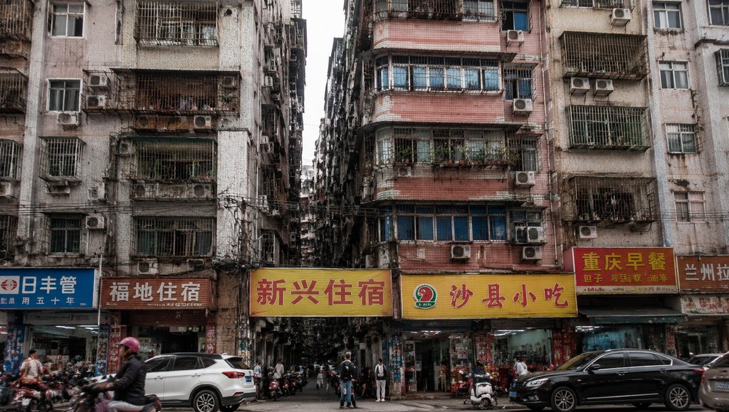 城中村握手楼密集建筑,杂乱招牌与电线交织,现代都市写实风格