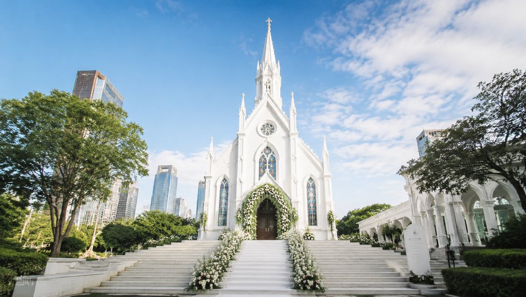 白色尖顶婚礼教堂,彩窗花艺装饰,现代都市背景