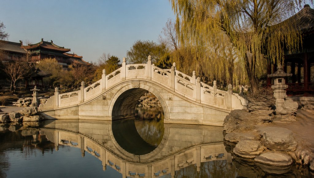 汉白玉拱桥横跨水面,雕栏精致,倒影清晰,古装宫廷风格写实建筑
