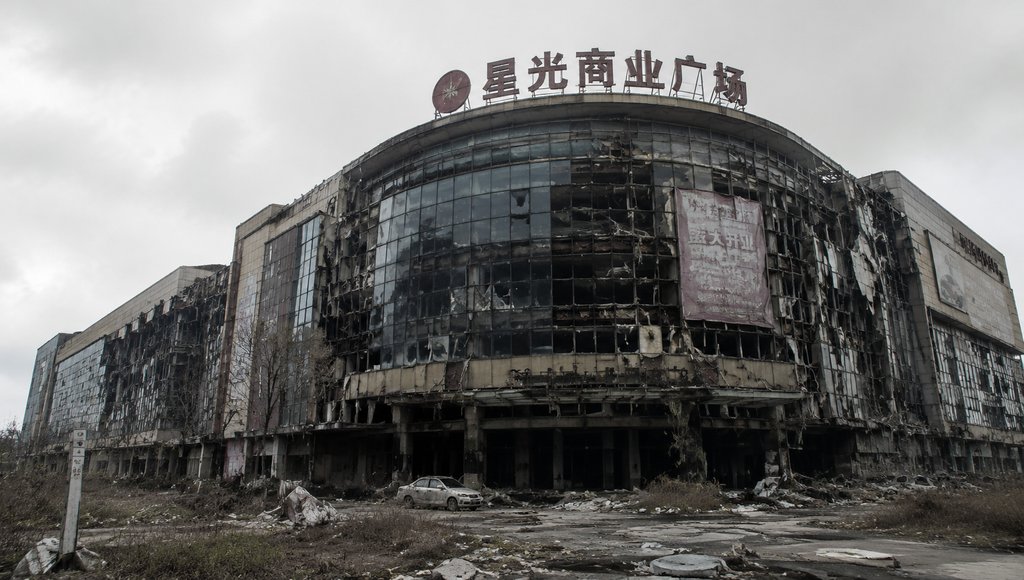 废弃商场建筑,玻璃幕墙破损,垂挂招牌,坍塌结构,末世废土风格
